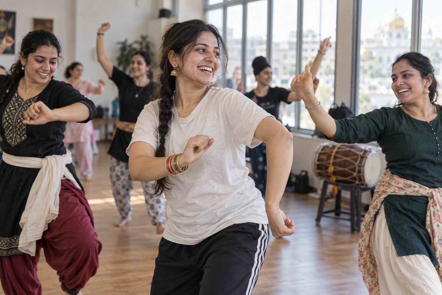 Three young women laugh together in a dance fitness class