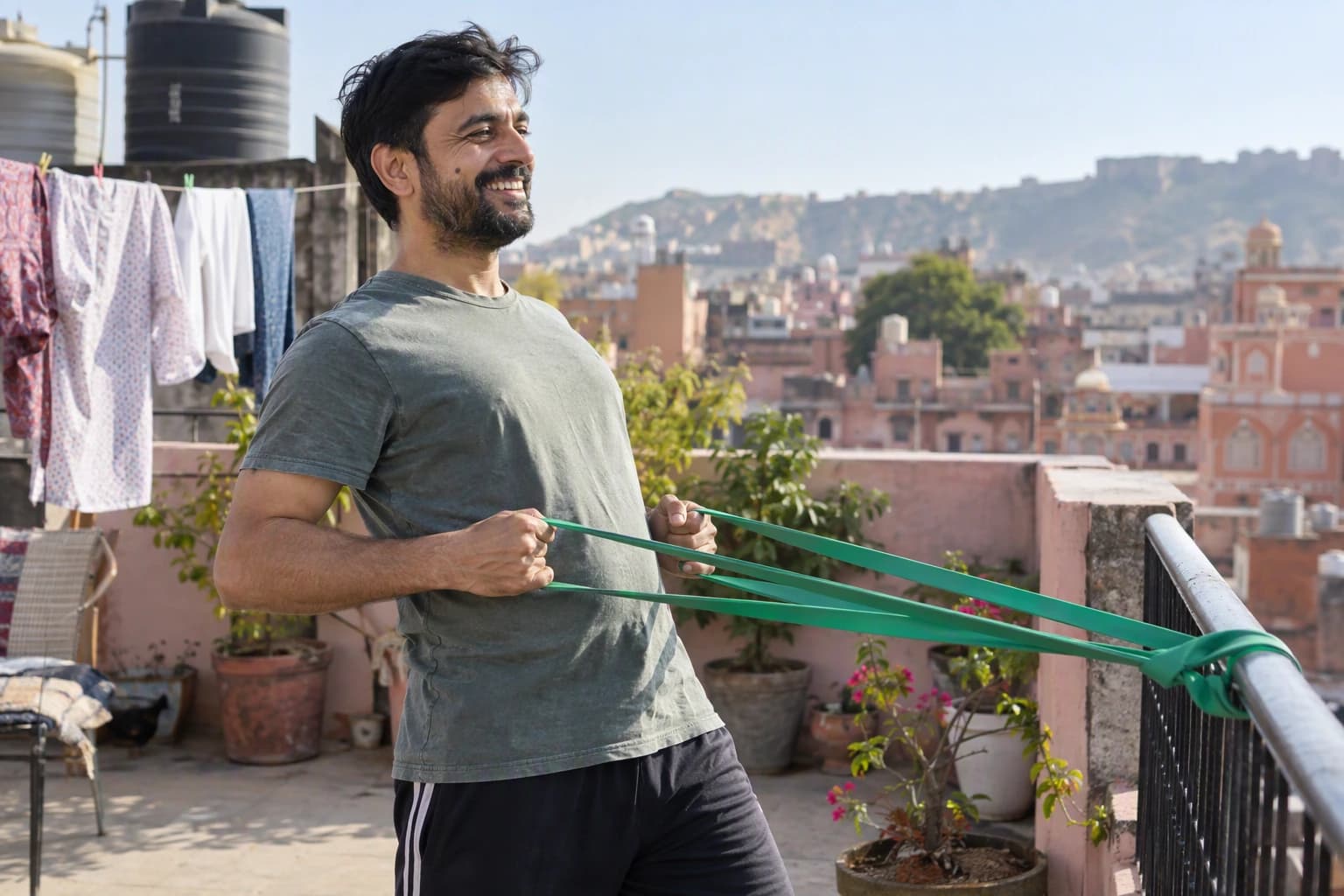 A man grins while exercising with a resistance band on his home terrace