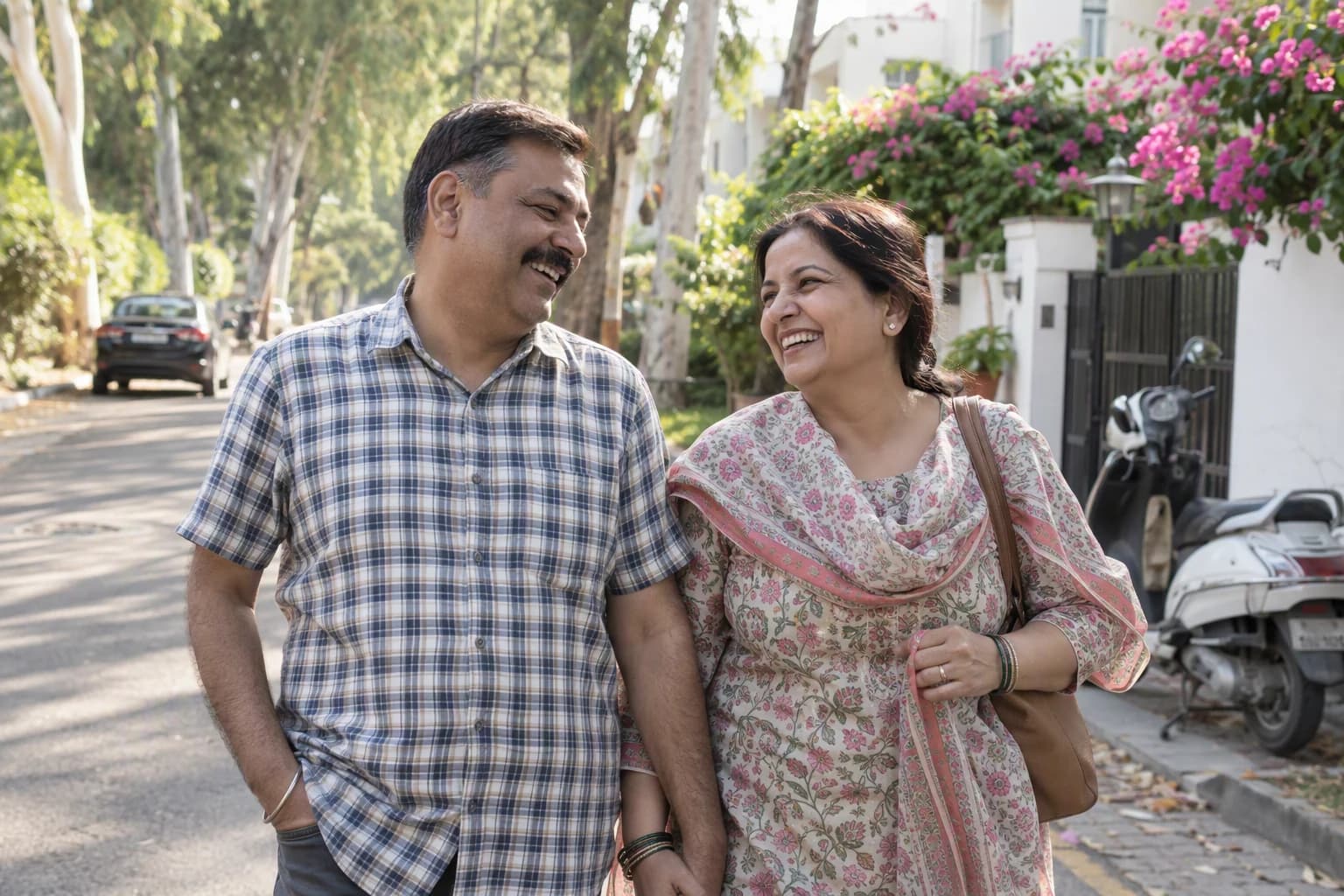 A couple laughs together on an after-lunch walk down a leafy lane