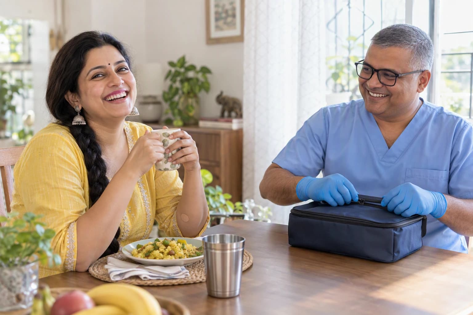 A woman in her mid-thirties with a long plait laughing at her dining table with a grey-haired male technician packing her finished sample